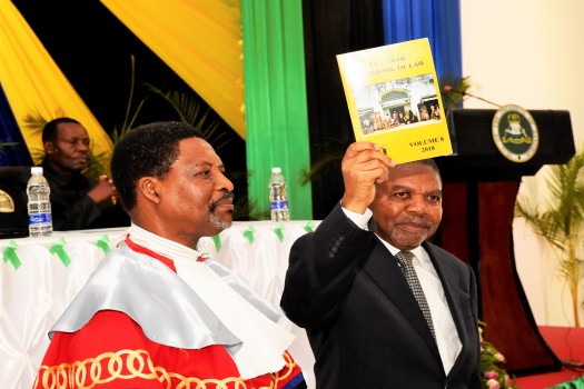 RAIS wa Zanzibar na Mwenyekiti wa Baraza la Mapinduzi Mhe.Dk. Ali Mohamed Shein, akionesha Kitabu cha Sheria  baada kukizindua.