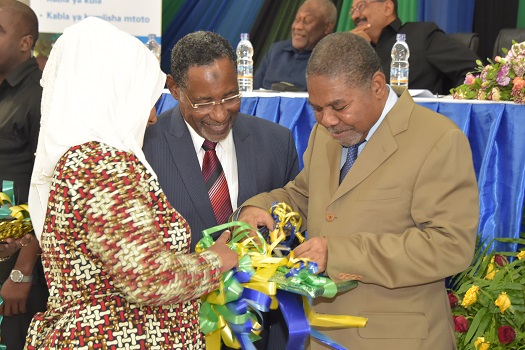 Rais wa Zanzibar na Mwenyekiti wa Baraza la Mapinduzi Dk.Ali Mohamed Shein akikata Utepe wa Vitabu vya Mpango kama ishara ya Uzinduzi rasmi wa mpango shirikishi wa kutokomeza Kipindupindu Zanzibar katika hafla iliyofanyika katika  ukumbi wa Idris Abdulwak