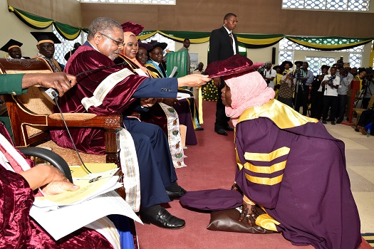 RAIS wa Zanzibar na Mwenyekiti wa Baraza la Mapinduzi pia ni Mkuu wa Chuo Kikuu cha Taifa Zanzibar (SUZA) Mhe.Dk.Ali Mohamed Shein akimtunuki Shahada ya Uzamivu ya Kiswahili Bi. Mwanahija Ali Juma, wakati wa Mahafali ya 15 ya SUZA yaliofanyika katika ukum